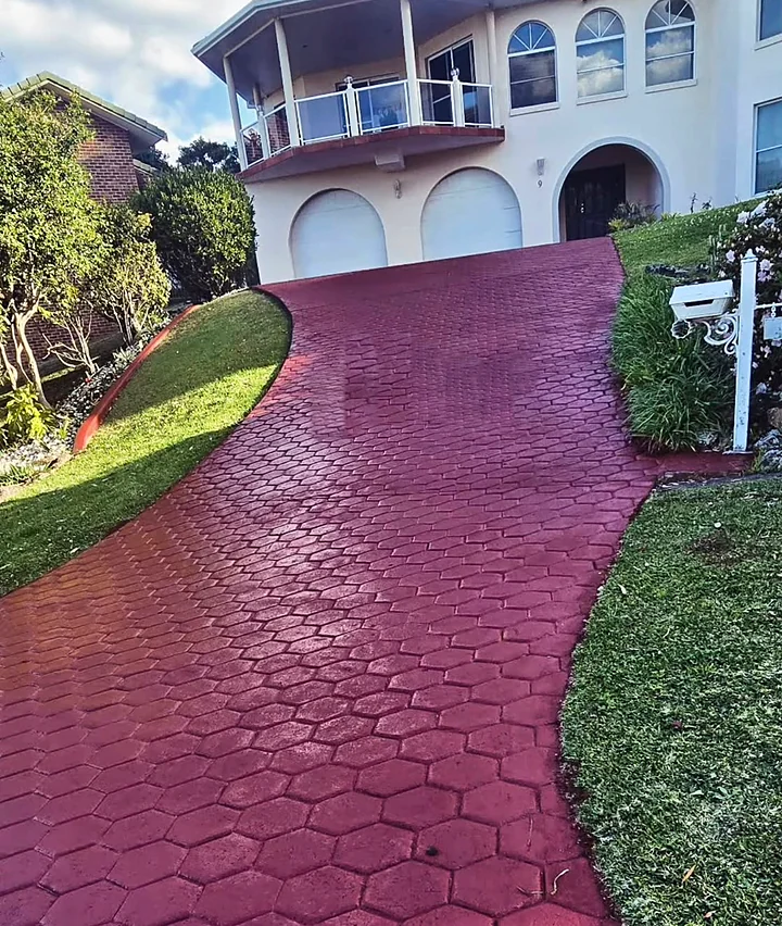 The same driveway and house after painting, the stamped concrete an even deep red